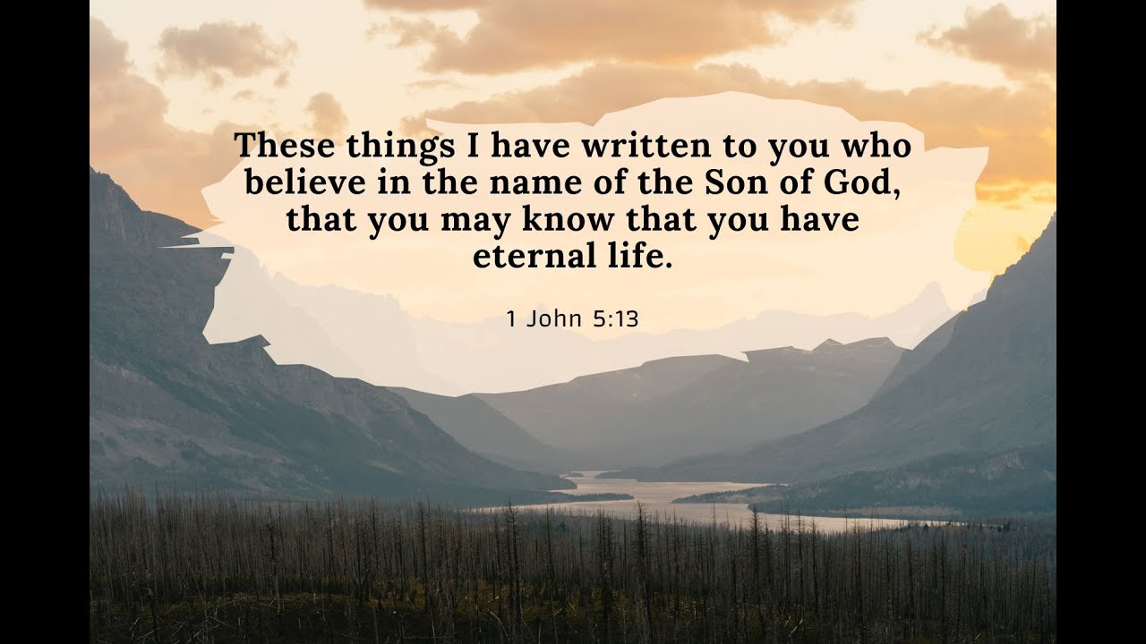 Sunset over distant mountains with a river valley; Bible verse 1 John 5:13 centered on screen.